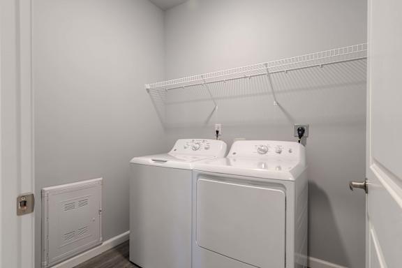 A white laundry room with a washer and dryer.