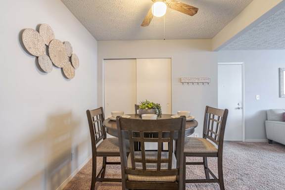 A dining room with a table and chairs.