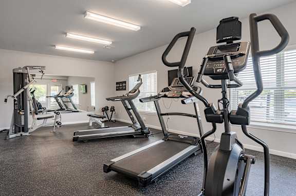 A gym with treadmills and elliptical machines.