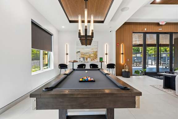 Billiards room with pool table and lounge seating at The Franklin at Marlboro Apartments, Marlboro