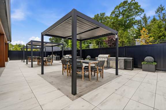 Outdoor patio with pergola dining area and grill at The Franklin at Marlboro Apartments, New Jersey, 07746