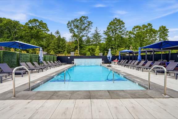 Outdoor swimming pool with lounge chairs and cabanas at The Franklin at Marlboro Apartments, Marlboro, NJ 07746