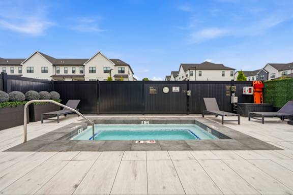 Hot tub with lounge seating and privacy fence at The Franklin at Marlboro Apartments, Marlboro, 07746