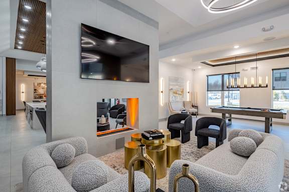 A modern living room with grey sofas and a large television.