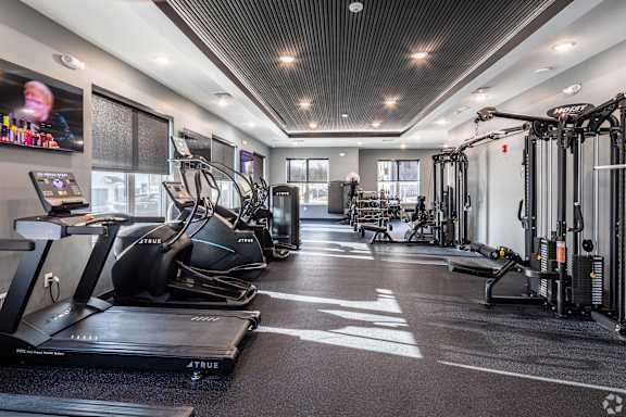 A gym with treadmills, elliptical machines, and other exercise equipment.