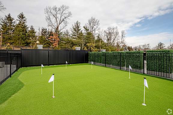 A golf course with green grass and white flags.