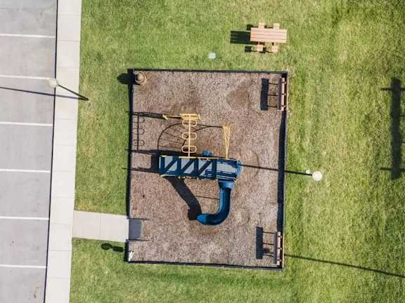 A playground with a blue slide and a yellow slide.