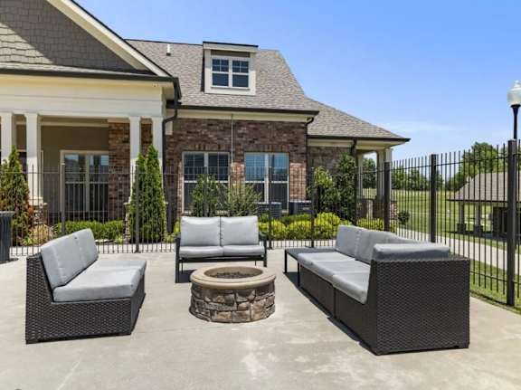 A patio with a fire pit and two couches.