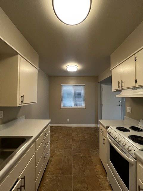 a kitchen with a stove and a window