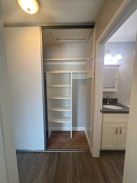 a white closet with shelves and a mirror in a room