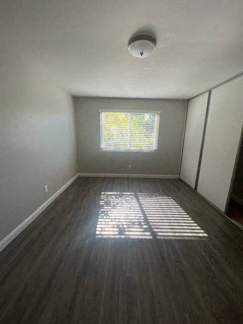an empty room with wooden floors and a window