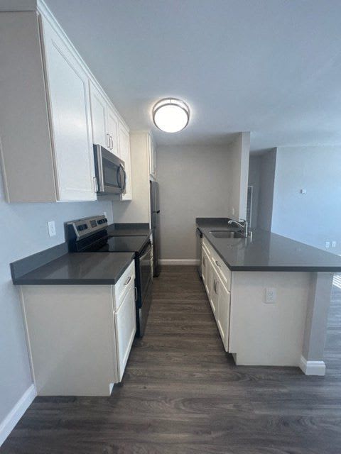 a kitchen with black counter tops and white cabinets