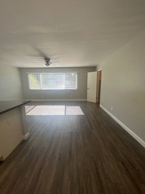an empty living room with a ceiling fan