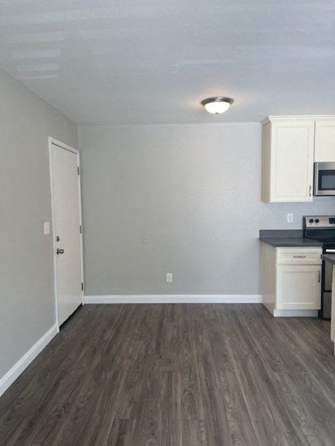 an empty kitchen with a stove and a microwave