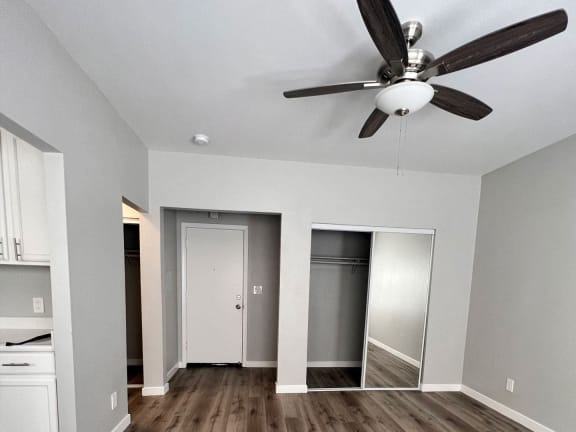 a living room with a ceiling fan and a closet