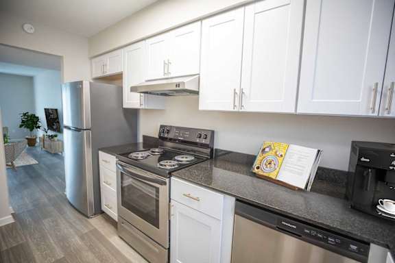 A kitchen with white cabinets and stainless steel appliances.
