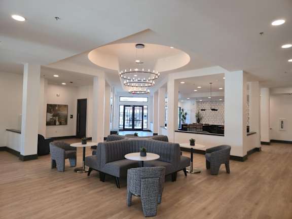 Modern lobby with circular seating and chandelier at Arden at Corinth Apartments, Corinth, 76210