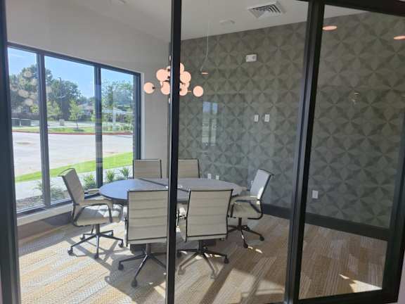 Conference room with glass walls and pendant lighting at Arden at Corinth Apartments, Corinth, Texas