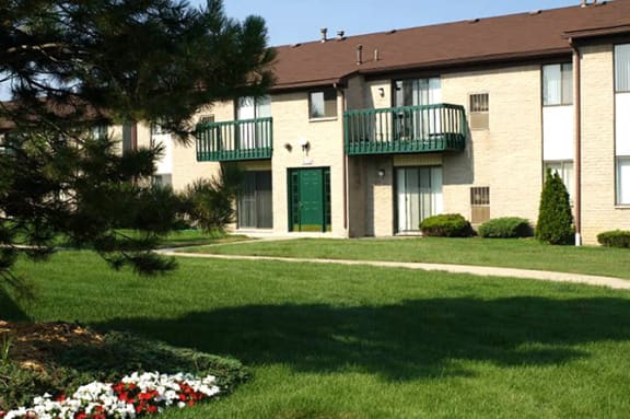 an apartment building with a green door and a lawn