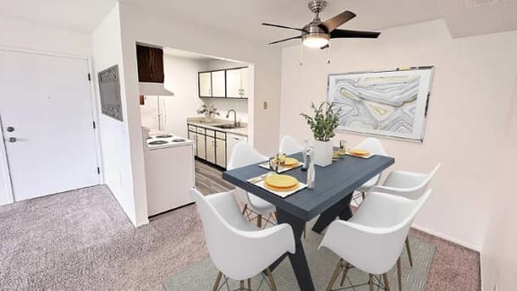 a dining room table with white chairs and a ceiling fan