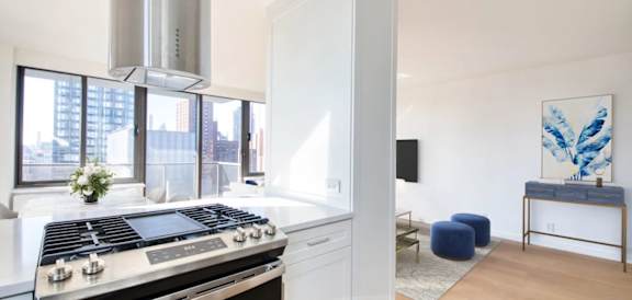 A modern kitchen with a stove top oven and a large window.