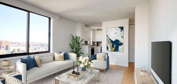 A living room with a white couch and a large painting on the wall.