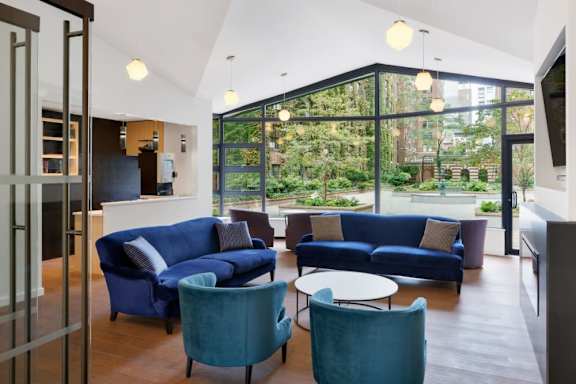 A living room with a blue couch and a green chair.