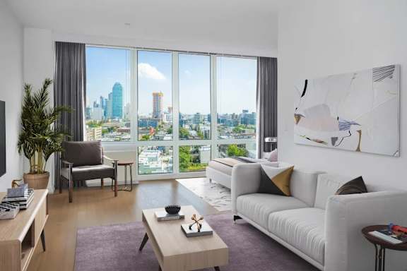 A modern living room with a view of the cityscape outside the large window.