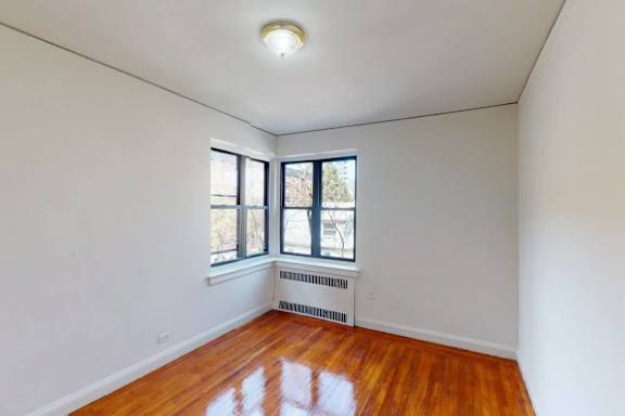 Empty room with a window and a radiator.