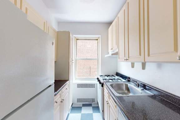 A kitchen with white appliances and wooden cabinets.