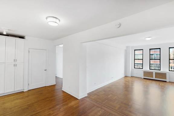 A room with wooden floors and white walls.