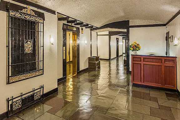 A hallway with a black gate and a gold door. at Sutton Collection Apartments, Apartments, New York, NY