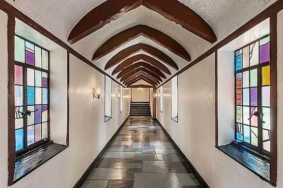 A long corridor with stained glass windows on both sides. at Sutton Collection Apartments, New York, 10022