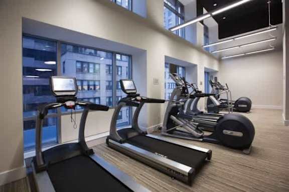 A gym with treadmills, elliptical machines, and other exercise equipment.