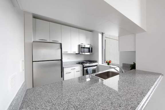 A modern kitchen with granite countertops and stainless steel appliances.