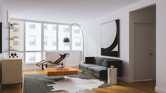 A modern living room with a grey couch, a wooden coffee table, and a large abstract painting on the wall.