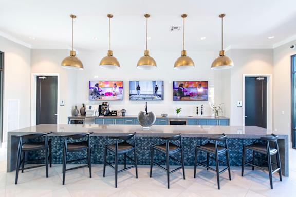 A modern kitchen with a bar area and a television mounted on the wall.