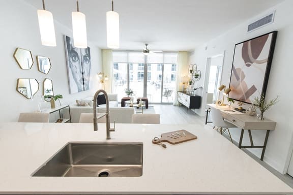 a kitchen counter with a sink and a view of a living room