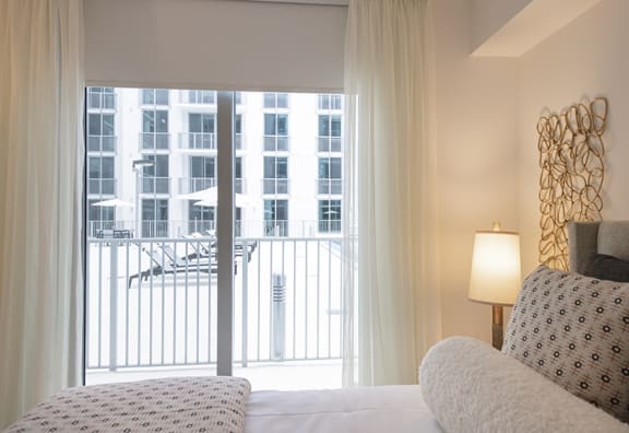 a bedroom with a view of a balcony and a bed