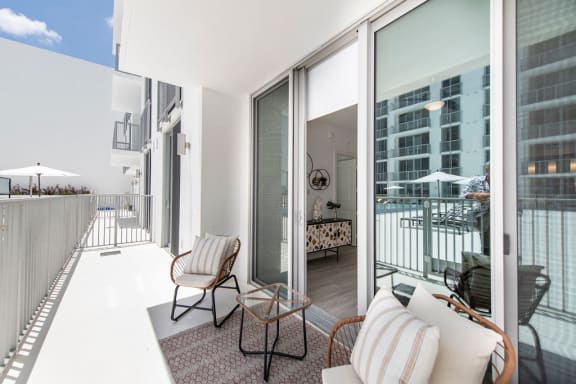 a living area with a couch and chairs and a balcony