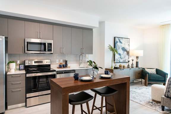 A modern kitchen with a wooden table and chairs.