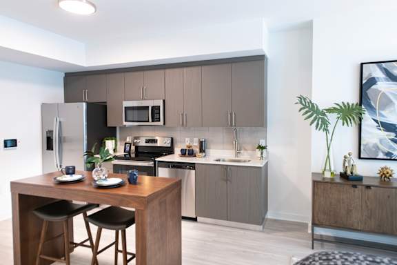A modern kitchen with a wooden island and bar stools.