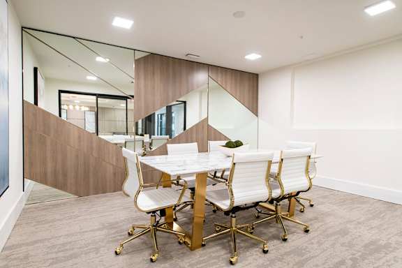 A conference room with a white table and chairs.