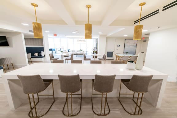 a large white table with chairs in a room with a living room