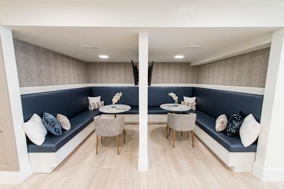 A modern living room with a grey sofa and a round table with chairs.