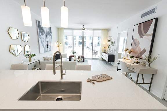 a kitchen with a sink and a view of a living room