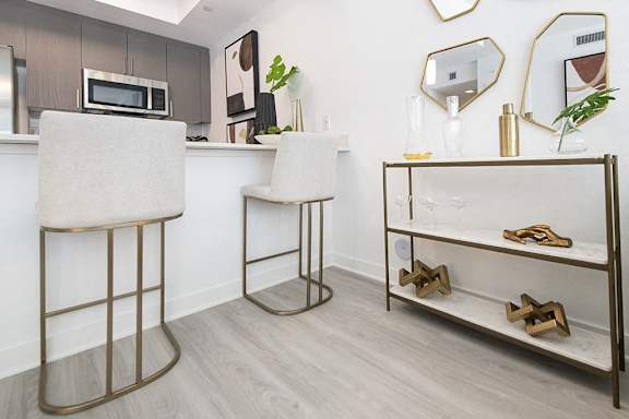 a kitchen with two bar stools and a counter with a microwave