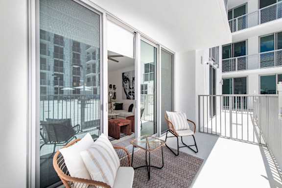 a living room with a couch and chairs on a balcony