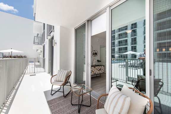 a living room with a balcony and a view of the ocean