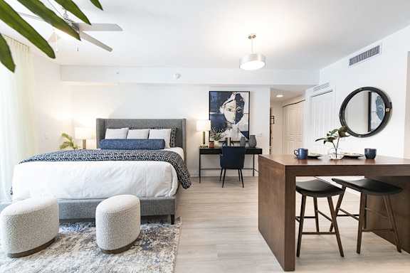 a bedroom with a bed and a desk and a living room
